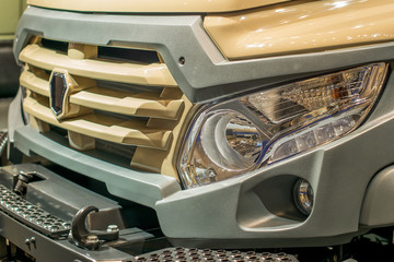 shiny chrome grille of a truck with a a powerful bumper and large headlights