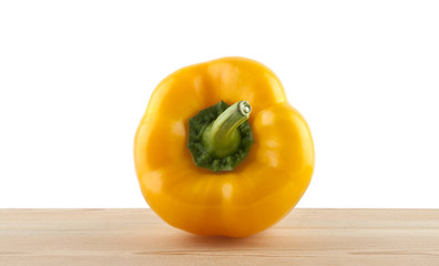 yellow bell pepper on a wooden table isolated on a white background