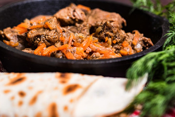 Beef stew in frying pan and vegetables