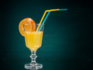 Cocktail Glas Orangensaft mit Orangenscheibe und Trinkhalmen nach rechts vertikal