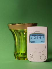 Geiger counter, showing the radiocarbon background of a glass made of uranium glass.