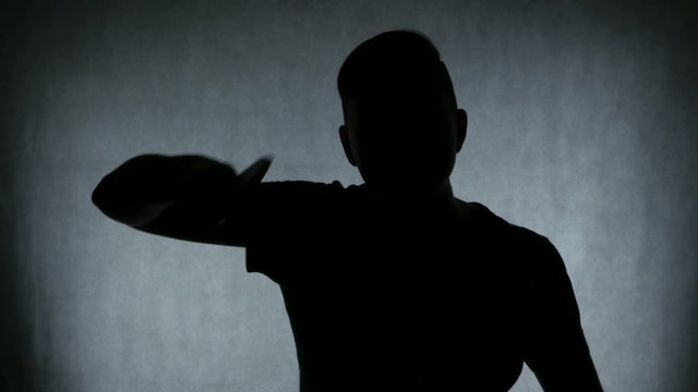 Bloody dark-haired murderer stabbing victim with knife, darkness and horror