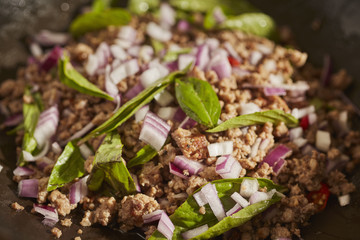 Larb, the Thai pork and herb salad in a black steel wok