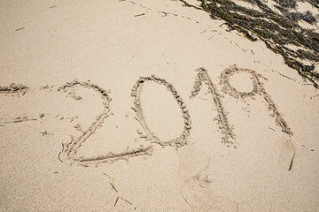 Sand photo written words and numbers on the beach with waves