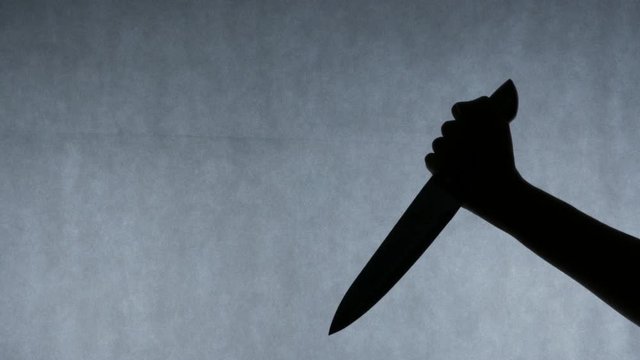 Hand of serial killer stabbing victim multiple times with a knife, crime scene. Killer on the loose