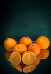 frische Orangen nebeneinander mit aufgeschnittener Orange grüner Hintergrund vertikal