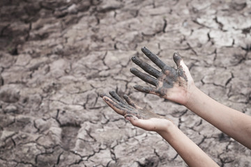 The women hand on the arid soil in hot weather lacked drinking water.
