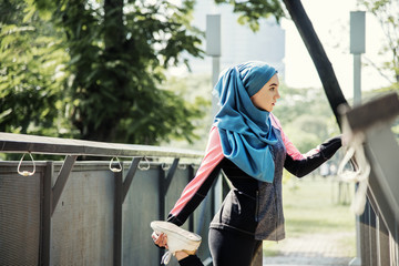 Islamic woman stretching after workout at the park