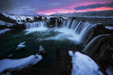 Photographer shoot a photo at Godafoss waterfall iceland in winter evening