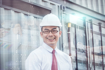 Fototapeta premium Handsome male engineer is smiling for work. The man is a white helmet is looking at the screen with aspiration.