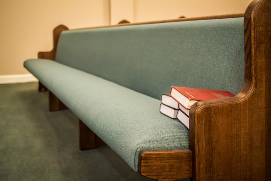 Empty pews with stacked books