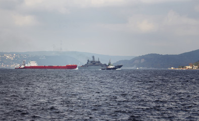 Fototapeta na wymiar Dry cargo vessel and war ship crossing Bosphorus strait in Tarabya area of Istanbul.