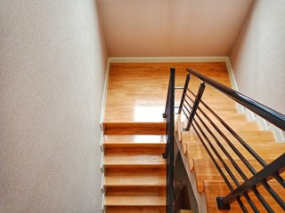 Staircase, wooden floor and black iron rail.
