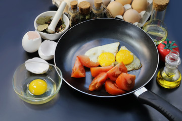 fried chicken eggs as a symbol of the heart in a frying pan. spices and bottled oils.