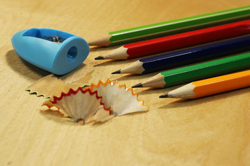 a shaving from pencils, a sharpener of pencils and pencils on a wooden background...