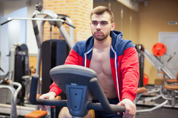 Fototapeta premium Fitness man on bicycle doing spinning at gym. Fit young man working out on gym bike.