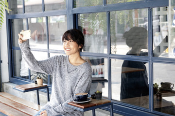 Asian women making selfie at cafe by her smartphone. Urban life concept.