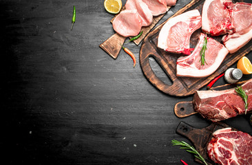 Different types of raw pork meat and beef with herb and spices.