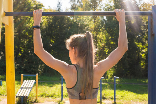 Active and young woman doing pullups.