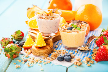 Orange persimmon blueberry smoothie with granola  and fruits. Selective focus. Copy space