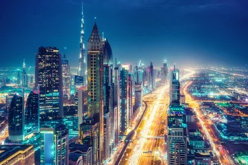 Fotobehang Spectacular urban skyline with colourful city illuminations. Aerial view on highways and skyscrapers of Dubai, United Arab Emirates. © Funny Studio