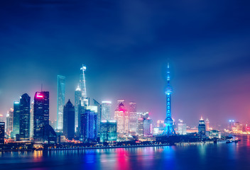 Obraz na płótnie Canvas Aerial panoramic view over a big modern city by night. Shanghai, China. Nighttime skyline with illuminated skyscrapers.