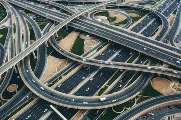 Gordijnen Aerial view of big highway interchange with traffic in Dubai, UAE, at day. Scenic cityscape. Colorful transportation, communications and driving background. © Funny Studio
