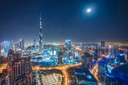 Aerial view on big futuristic city by night. Skyscrapers of Dubai, United Arab Emirates. Nighttime skyline.