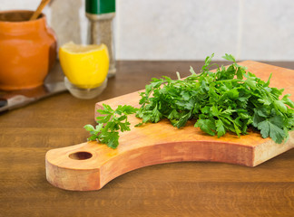 Fresh parsley on the wooden cutting board on cook table