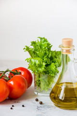 Olive oil, green salad lettuce and fresh tomato