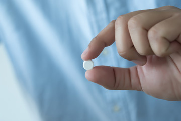 Naklejka premium Medicine and health care concept man pours the pills out of the bottle holding medicine