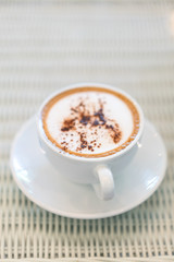 Hot cappuchino coffee cup on table