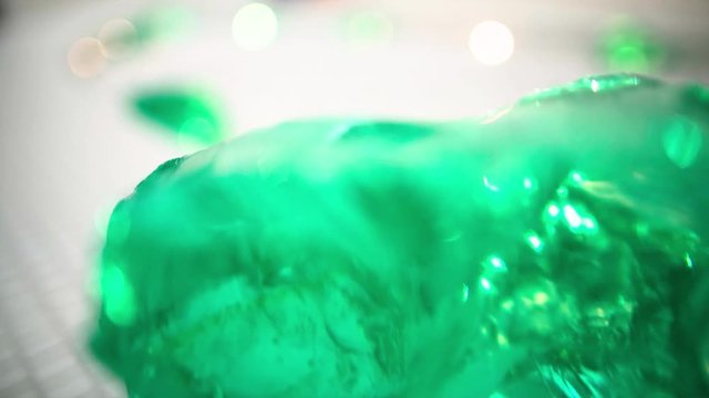 Close up of a beautiful chunk of uncut emerald as the camera tracks past