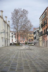 Obraz premium Typical small square in Venice old town with an old well and coble stone ground, Venice , Italy