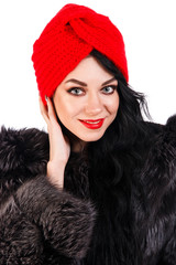 Pretty young woman in a black fur coat and turban