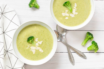 Broccoli soup with almonds on white background, top view.