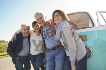 Group of senior friends standing by camper van