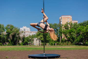 Fit attractive girl dancing near portable pole at summer day © Smile