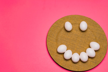 A plate of smiley uncolored Easter Eggs.