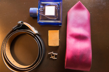 Groom’s accessories: leather belt, cufflinks, perfume, necktie, cigarette lighter. Wedding