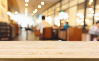 Wood table with Restaurant cafe or coffee shop interior with people abstract defocused blur background