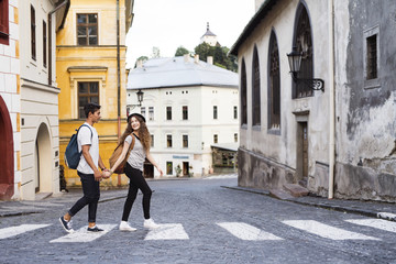Two young tourists crossing the road in the old town.