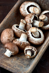 Fresh champignon mushrooms on wooden table. Top view