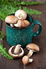 Fresh whole  button mushrooms - champignon  in  mug  on  rustic wooden counter ready  for cooking