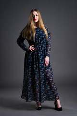 Fototapeta premium Plus size fashion model in long dress, fat woman on gray background, overweight female body