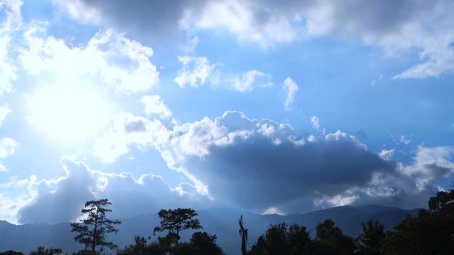 Bright blue sunny cloudy summer sky with mountain silhouette 4k