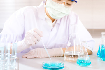 Asian women scientist with test tube making research in clinical laboratory.Science, chemistry, technology, biology and people concept