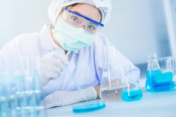 Asian women scientist with test tube making research in clinical laboratory.Science, chemistry, technology, biology and people concept
