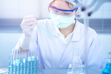 Asian women scientist with test tube making research in clinical laboratory.Science, chemistry, technology, biology and people concept