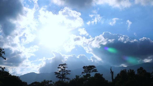 Bright blue sunny cloudy summer sky with mountain silhouette 4k